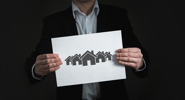 Estate agent holding a drawing of multiple houses